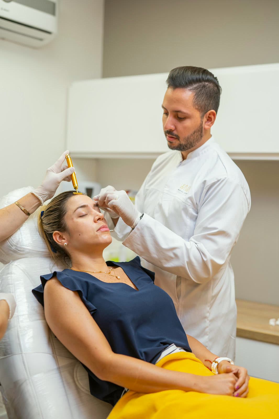El Dr. Diego Serna realiza un tratamiento facial a una paciente en un consultorio de WIWA Medical Center